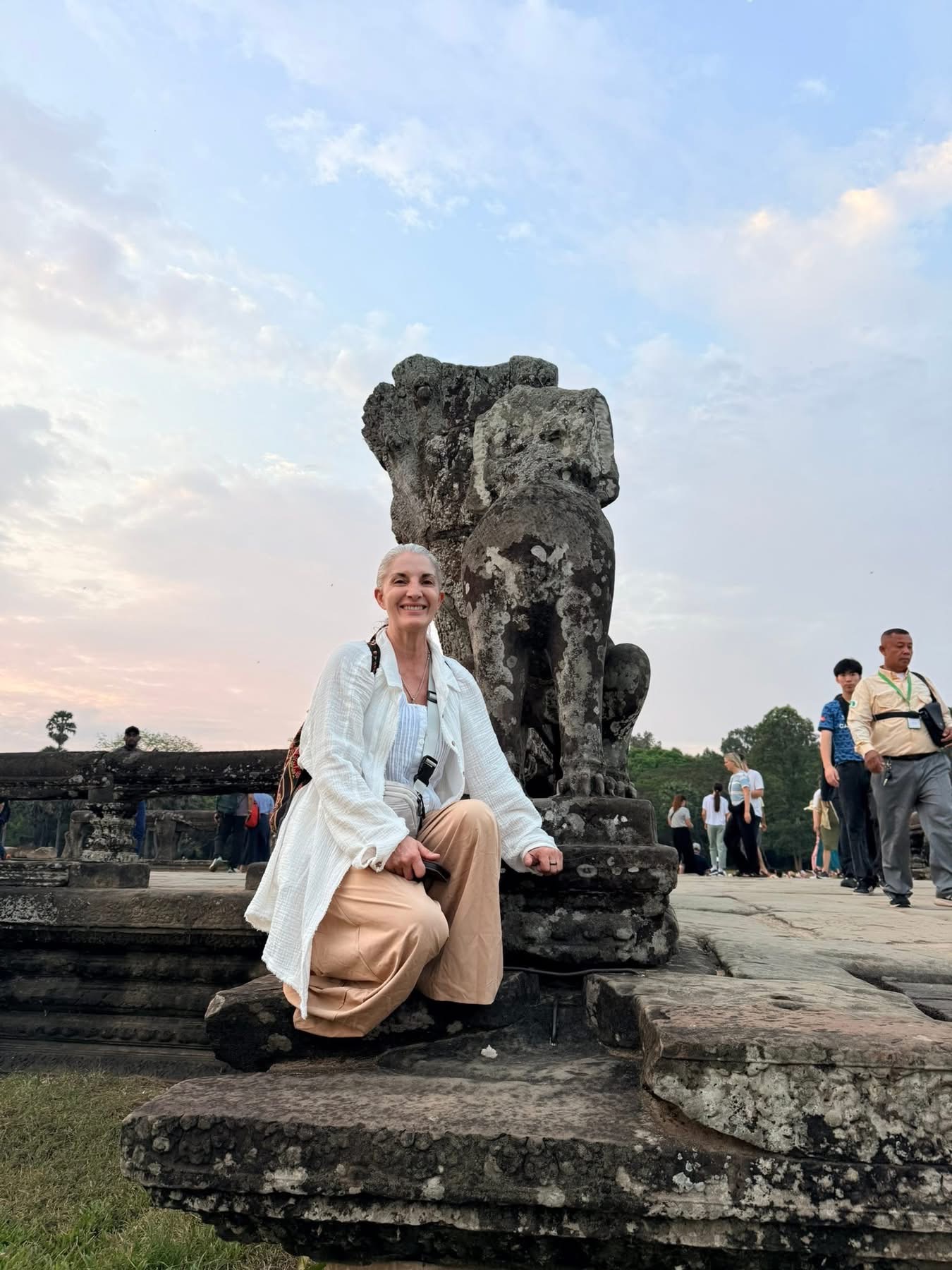 Armanda seated beside a weathered stone carving beneath an open sky