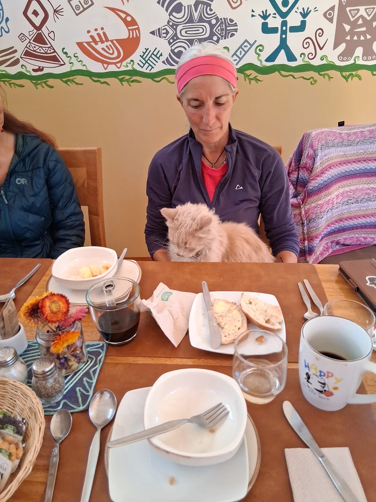 Armanda seated at a breakfast table with an orange cat on her lap