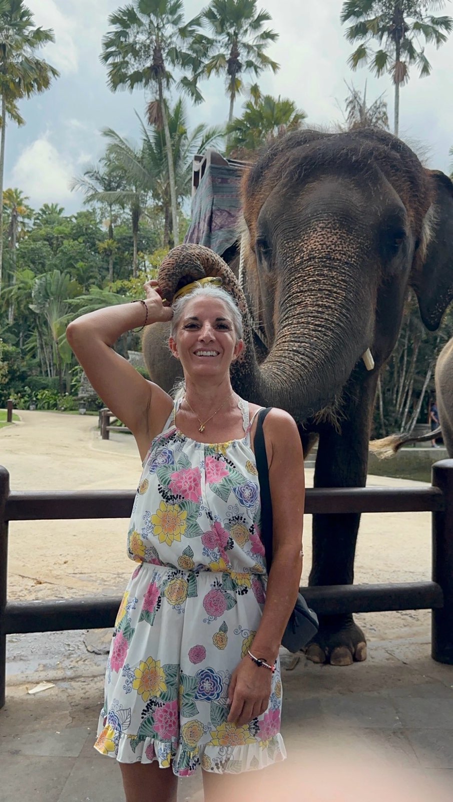 Armanda in a floral dress standing in front of an elephant