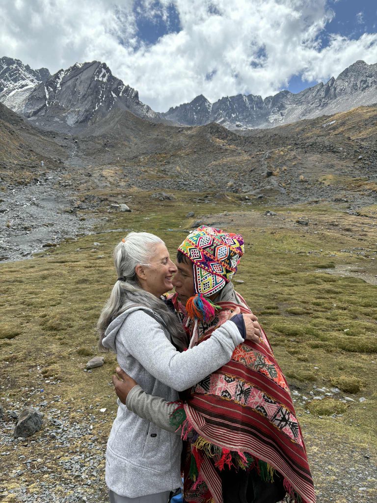 Two people embracing beneath a mountain range