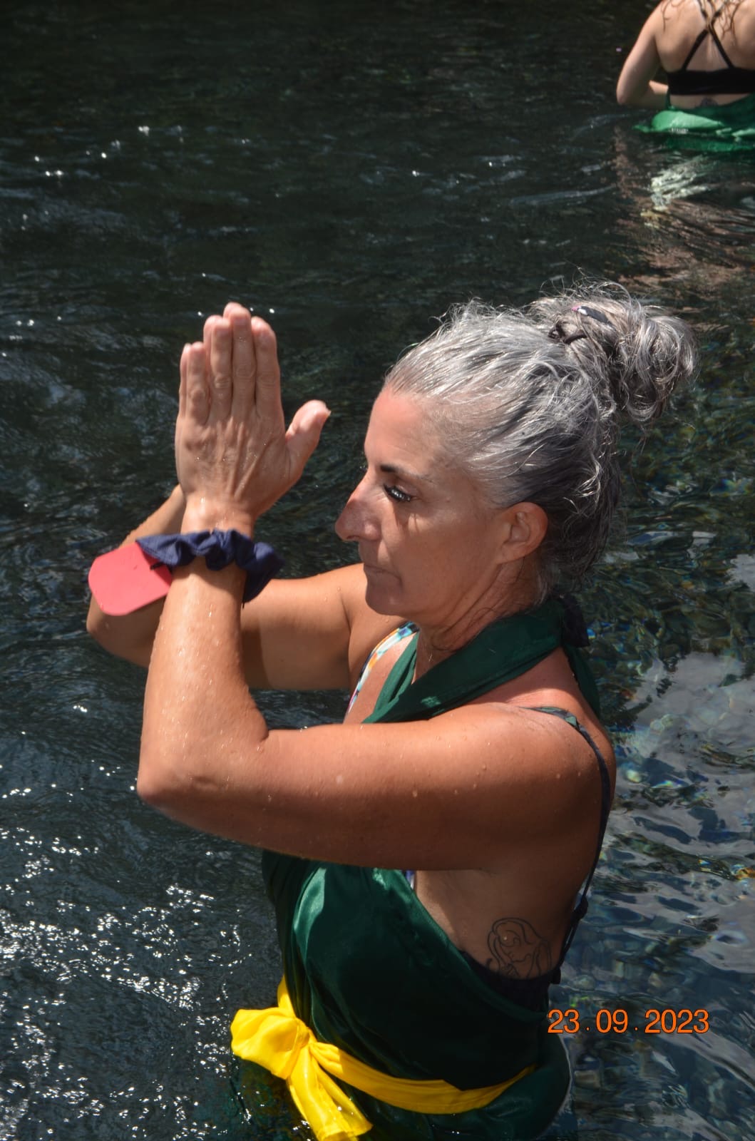 Armanda standing in water with her palms together near her forehead