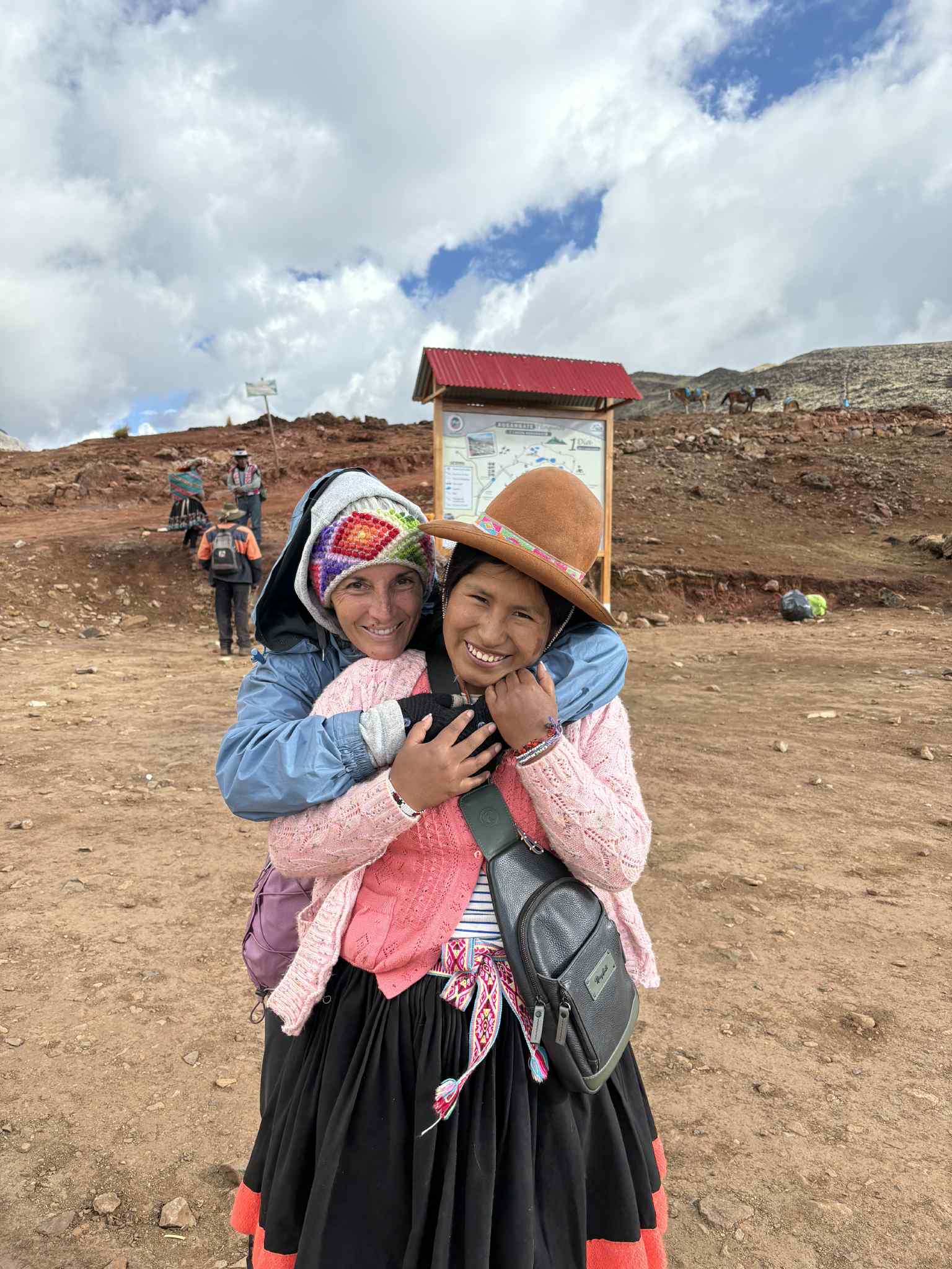 Two people embracing outdoors beside a small building